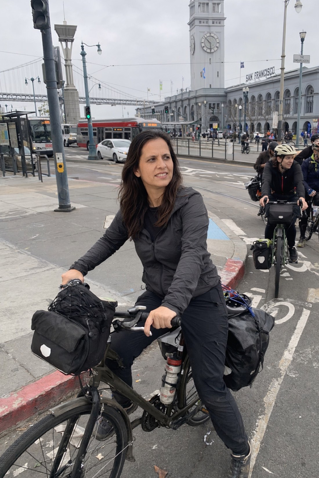 Woman on a bike at a city intersection with other cyclists