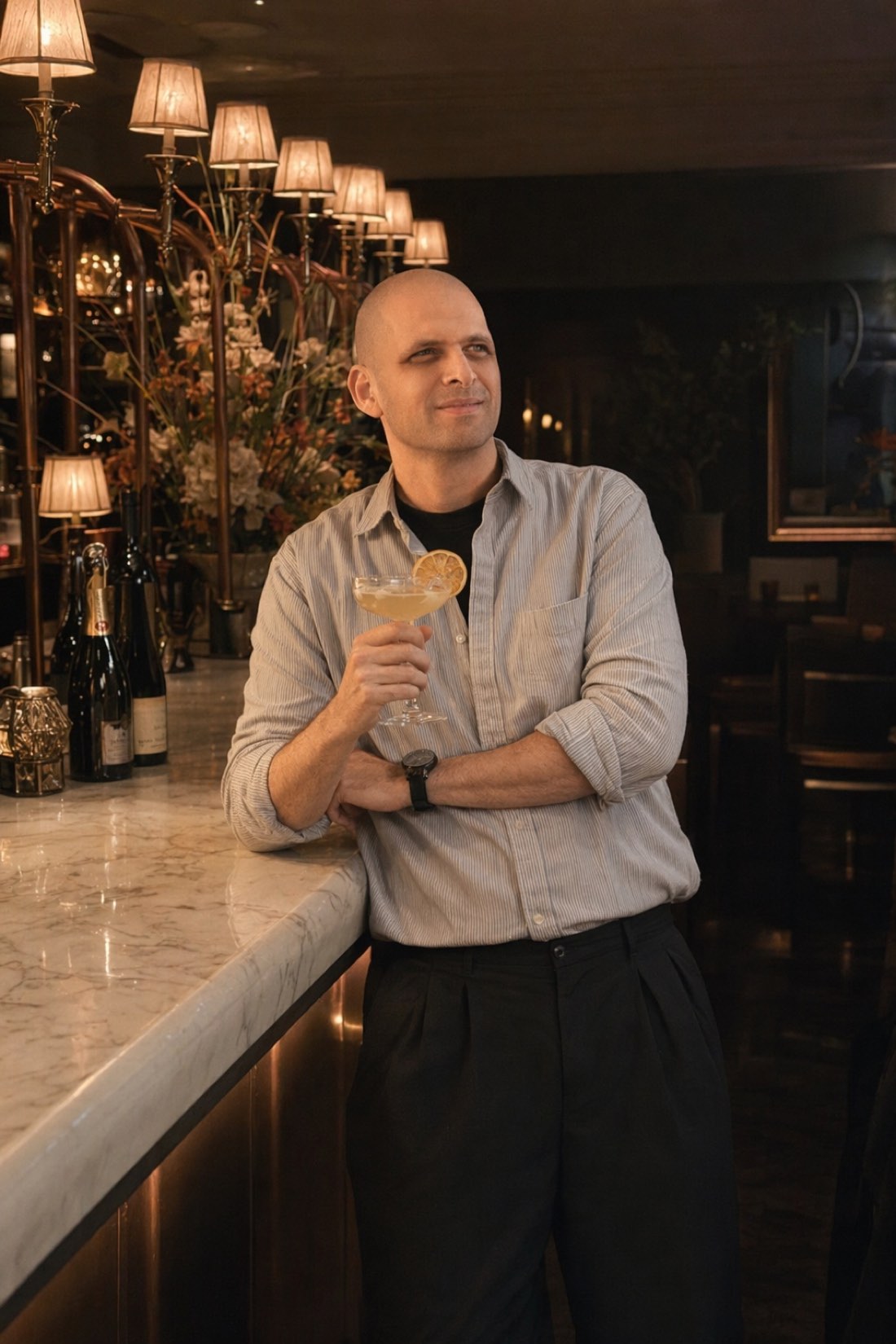 Man with a cocktail at an elegant bar, the same face and the same build he brings to the date