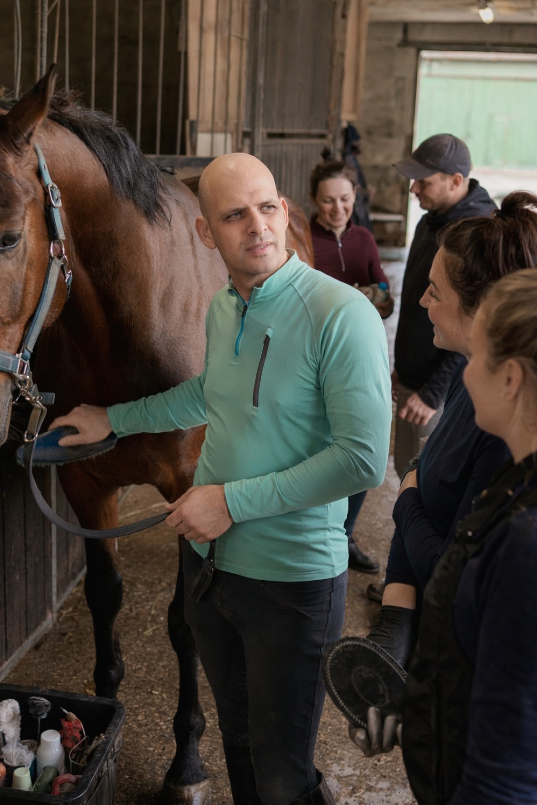 Man grooming a horse with people around, a candid AI photo for a Tinder profile