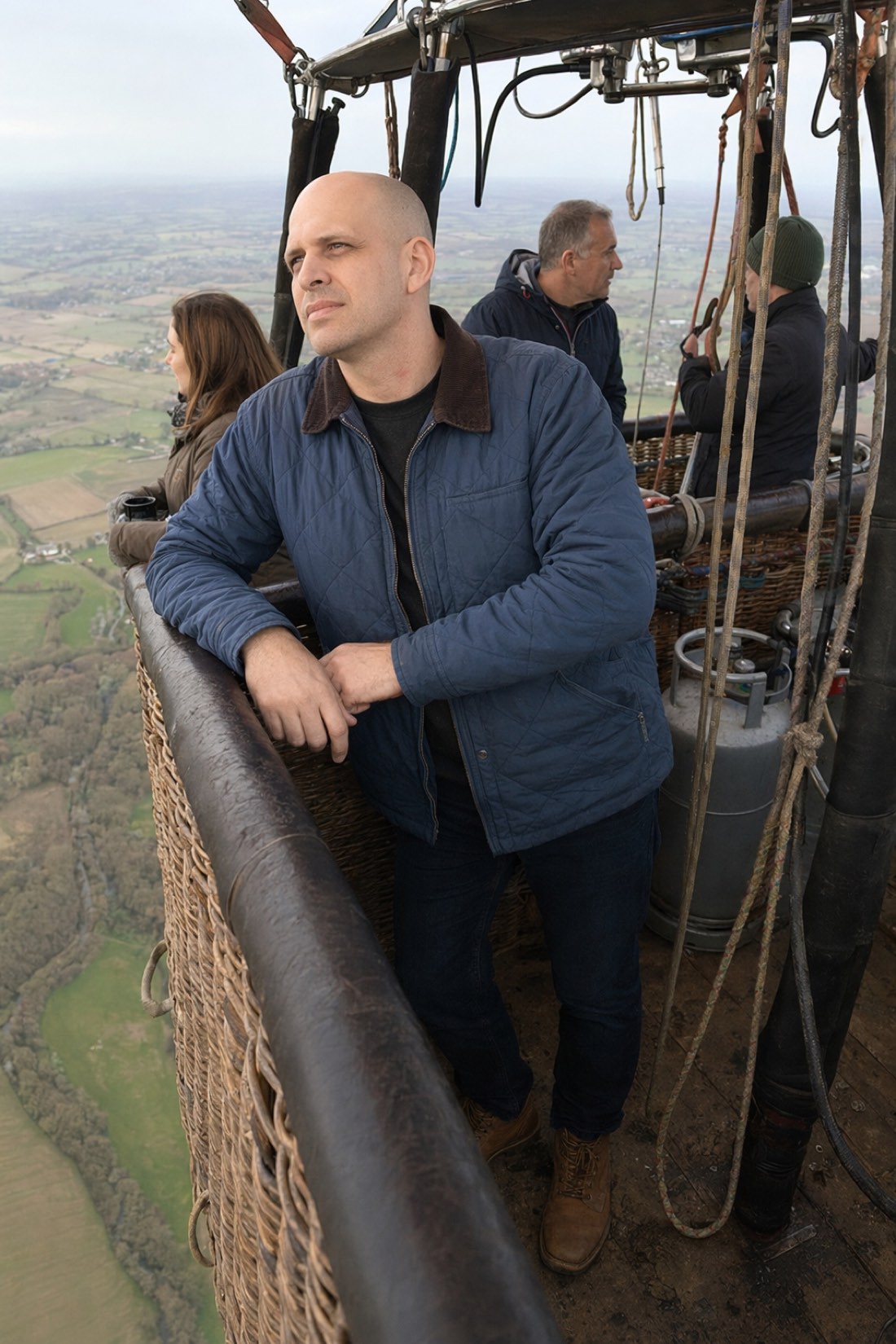 Man in a hot air balloon over green countryside, a realistic AI travel photo of himself