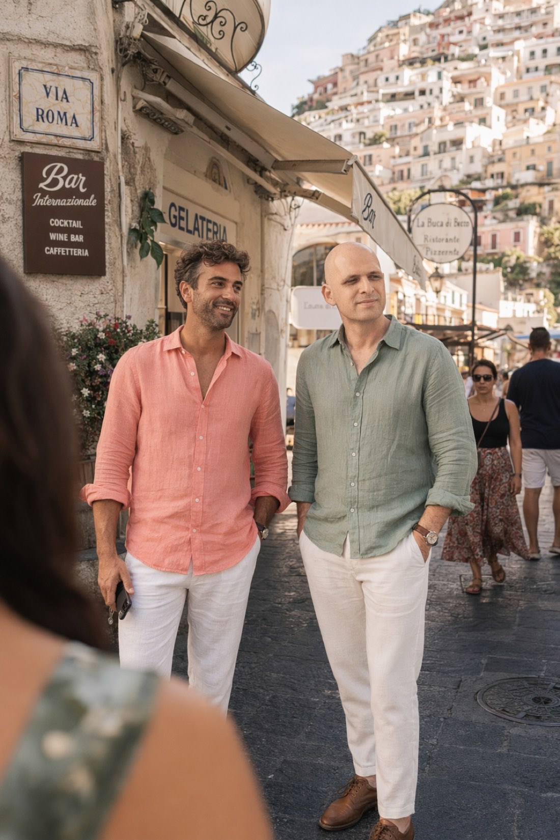 Two friends pausing outside a gelateria on the Amalfi coast, completely at ease