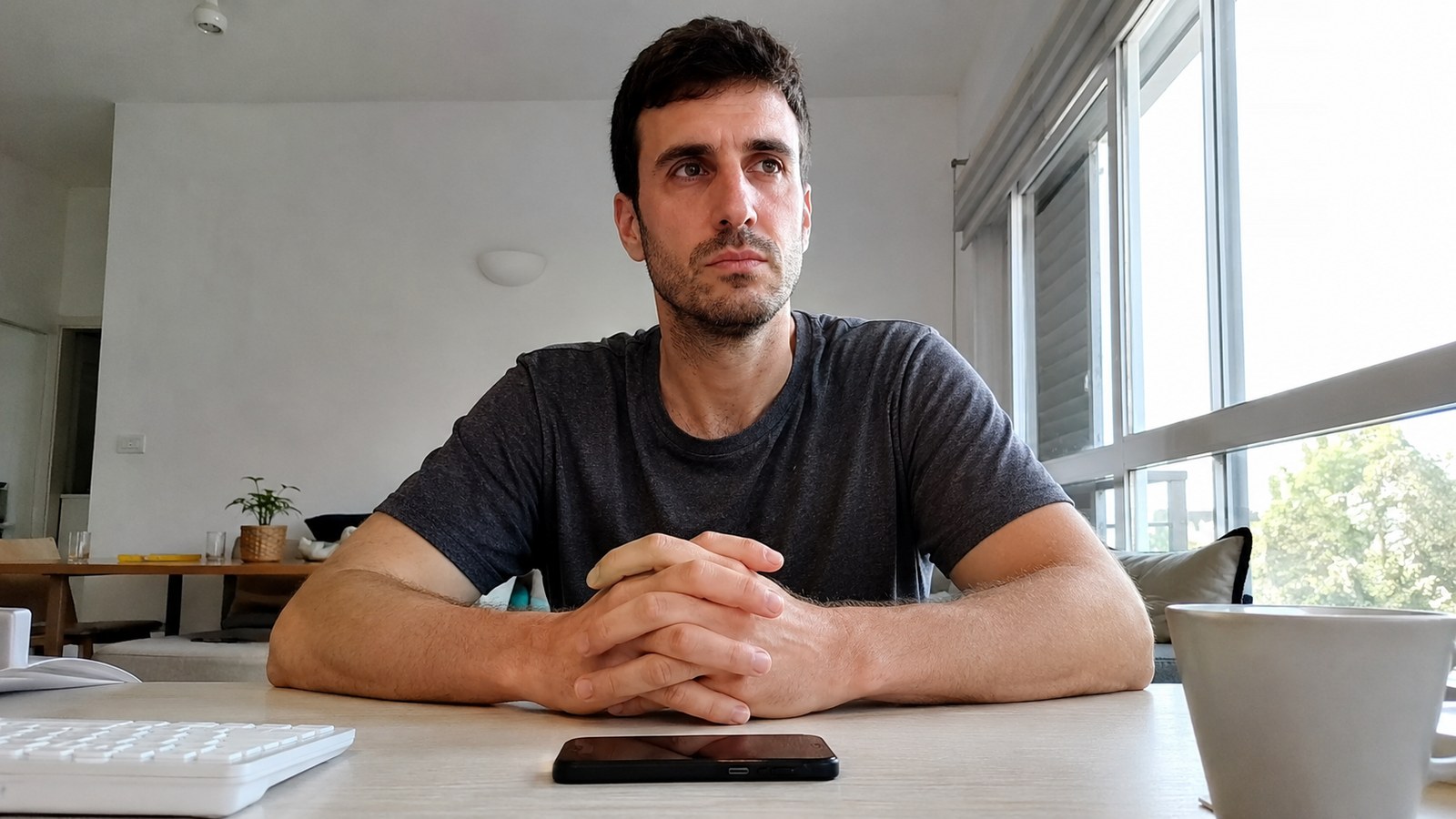 A man at a clean desk in the morning, phone face down, fresh-start energy