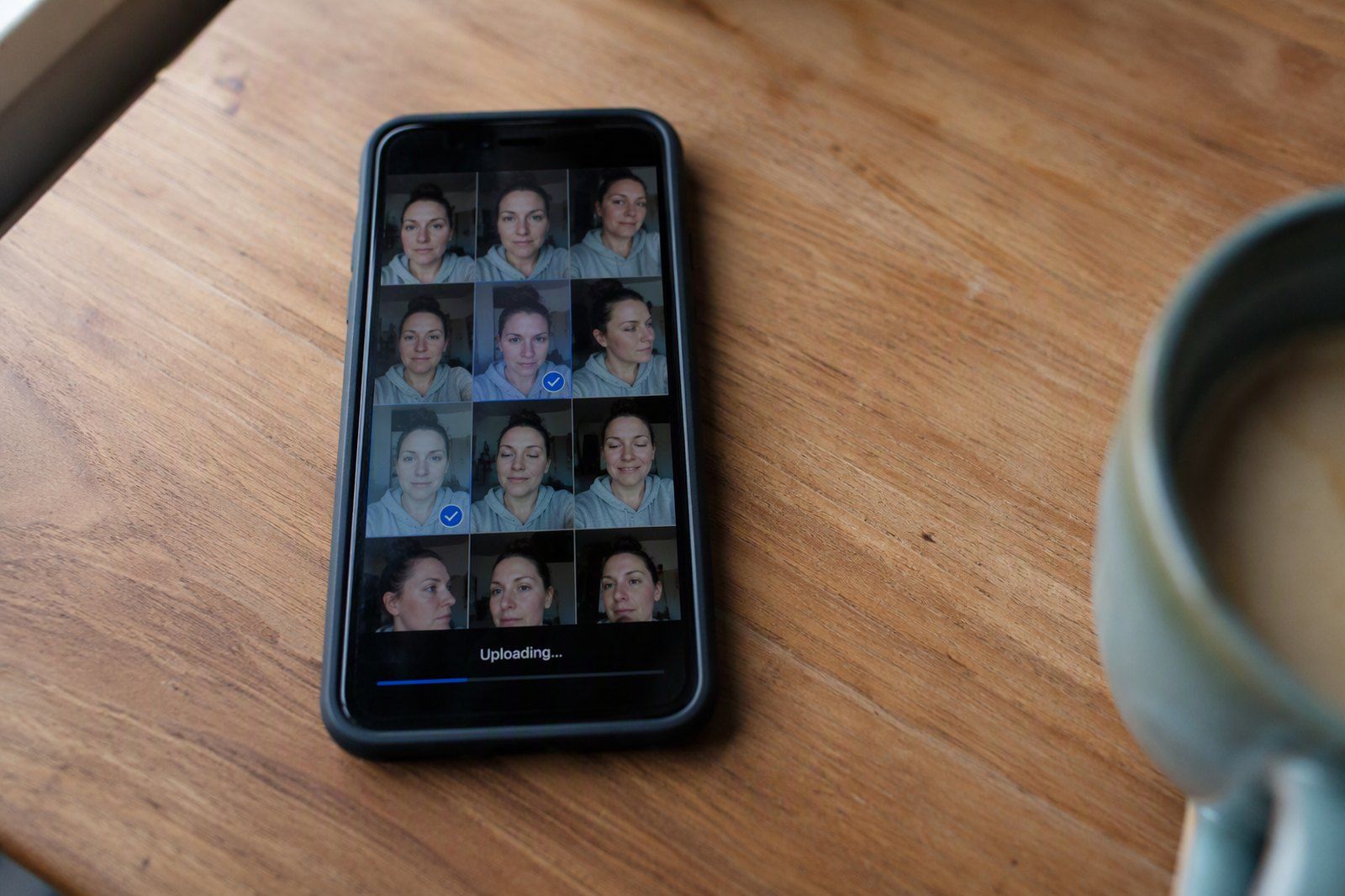 A phone gallery with several selfies selected, mid-upload