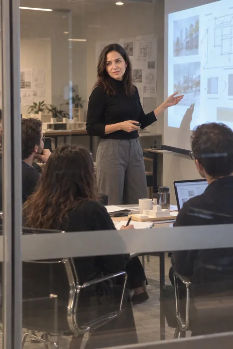 AI LinkedIn photo example: presenting in an architecture studio, seen through the glass