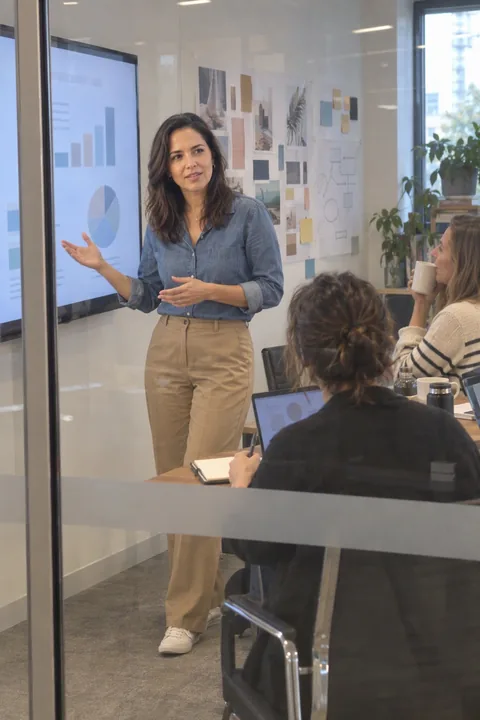 AI LinkedIn photo example: presenting from a TV screen in a creative agency room